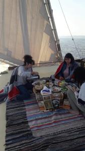 Un groupe de personnes assises autour d'une table sur un bateau dans l'établissement Salah El Din Restaurant on the Nile Corniche, à Assouan