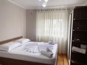 1 dormitorio con 1 cama con toallas en Aimari’s Apartment, en Shkodër