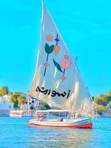 a boat with a sail on the water at Salah El Din Restaurant on the Nile Corniche in Aswan