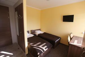 Cette chambre comprend deux lits et une télévision. dans l'établissement Hotelik A2, à Pruszków