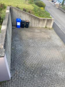 three trash cans sitting next to a concrete wall at Main Weindorf Unterkunft in Sulzfeld am Main