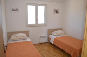 two beds in a room with a window at Apartment Quattro in Trogir