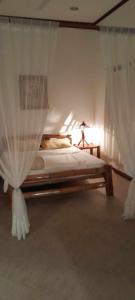 a bedroom with a bed with white curtains at Bonita Oasis Beach Resort in Moalboal