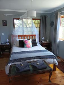 1 dormitorio con 1 cama grande y toallas. en Lavender Cottage, en Ciudad del Cabo