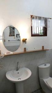 a bathroom with a sink and a mirror and a toilet at Bonita Oasis Beach Resort in Moalboal