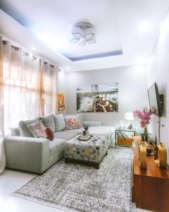 uma sala de estar com um sofá e uma mesa em The Hatua Peaceful Homeaway Haven em Arusha