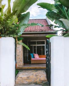 une maison avec une terrasse couverte dotée d'un canapé dans l'établissement The Hatua Peaceful Homeaway Haven, à Arusha