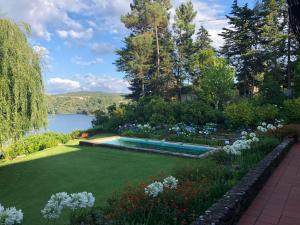 a garden with a swimming pool and flowers at Quinta do Troviscal in Castelo do Bode