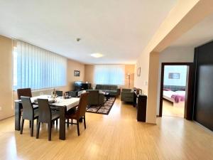 een eetkamer en een woonkamer met een tafel en stoelen bij Wili Tatry Apartments in Tatranská Lomnica