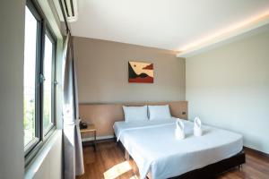 a bedroom with two beds and a window at Siri Hotel in Vientiane