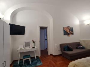 - un salon avec un canapé et un bureau avec un ordinateur dans l'établissement Casa Giulia, à LʼAquila