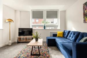a living room with a blue couch and a tv at Bright 1 Bedroom Apartment in Central Rotherham in Rotherham