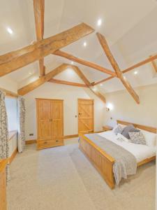 um quarto com uma cama grande e vigas de madeira em West Nymph Holiday Cottages Leafy Nook em South Tawton
