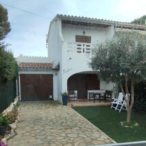 een wit huis met een patio en een tafel bij Casa katy in L'Escala