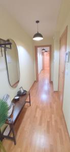 a living room with a mirror and a wooden floor at ALMA DE MALPICA apartamento nuevo en el centro in Malpica +34 photos