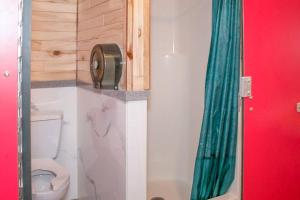 a bathroom with a toilet and a green shower curtain at Moab RV Resort Glamping Setup Tent in RV Park #4 OK-T4 in Moab