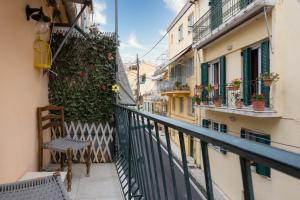 einen Balkon mit einem Stuhl und Blumen auf einem Gebäude in der Unterkunft Port loft in Mantoúkion