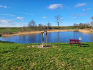 a red bench sitting in front of a lake at Alte Dorfschule im Recknitztal in Selpin