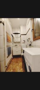 uma pequena cozinha com electrodomésticos brancos e piso em madeira em The ARK Eco Homestay em Esch-sur-Alzette