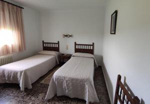 Habitación con 2 camas y ventana en Hostal El Molino, en Villahermosa