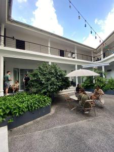 un groupe de personnes assis à l'extérieur d'un bâtiment dans l'établissement Centerpoint Koh Phangan New, à Thongsala