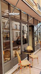 une table et des chaises à l'extérieur d'un magasin dans l'établissement Appart Hôtel Victoria, à Vincennes