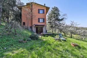 a house on a hill with a table and chairs at Bologna's Animal Sanctuary in San Lorenzo in Collina