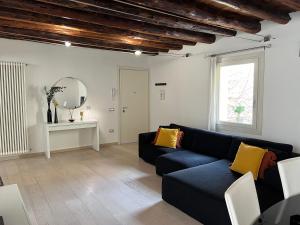 a living room with a blue couch and a mirror at Ca' Del Vecio, in centro storico, Piazza Garibaldi in Bassano del Grappa