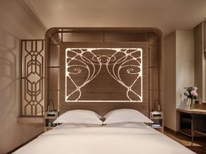 a bedroom with a large bed with a wooden headboard at Domus Blanc Boutique Hotel in Chania Town