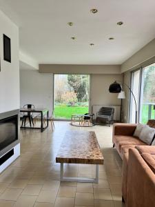 a living room with a couch and a table at La Lumineuse du Moulin in Saint-Germain-sur-Bresle