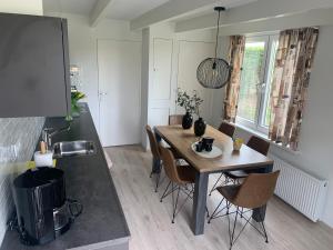 a kitchen with a table and chairs in a room at Karreveld in Zonnemaire