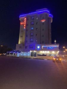 a large building with blue lights on it at night at Spice Hotel in Kuwait