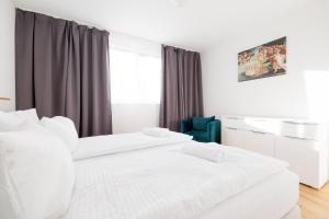 Duas camas brancas num quarto com uma janela em SYMPHONY Apartments 42 - Modern Loft with Terrace and Grill in Central Location em Viena