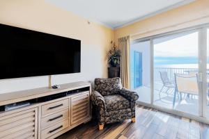 sala de estar con TV de pantalla plana y silla en Sea Breeze 508, en Gulfport