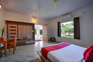 a bedroom with a bed and a desk and a window at Aranya Vilas, Ranthambhore in Khilchipur +32 photos