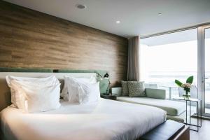a bedroom with a large white bed and a window at Octant Ponta Delgada in Ponta Delgada
