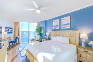 a bedroom with a large white bed with blue walls at Sea Breeze 311 Deluxe in Biloxi