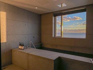 La salle de bains est pourvue d'une baignoire et d'une fenêtre. dans l'établissement Banwol Poolvilla, à Busan