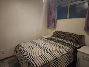 een kleine slaapkamer met een bed en een raam bij Ocean view @ 10 south in Durban