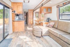 a living room with a couch and a kitchen at Moab RV Resort Outdoor Glamping Destination RV OK40 in Moab