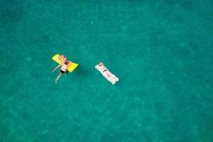 a person laying on a surfboard in the water at LILI KALI in Kali
