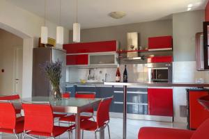 a kitchen with red cabinets and a table with red chairs at LILI KALI in Kali