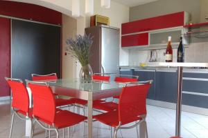 a kitchen with red chairs and a table with a vase of flowers at LILI KALI in Kali +41 photos