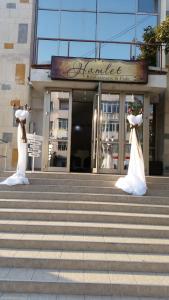 dos estatuas de novia y novio delante de un edificio en Hamlet Hotel, en Bacău