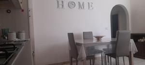 y cocina blanca con mesa de comedor y sillas. en La casa di Carlotta, en Cerreto di Spoleto