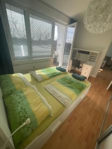 1 cama grande con sábanas verdes y amarillas en una habitación en Park View City Center Location Apartment with Balcony, en Bratislava