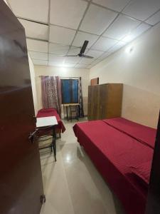 a room with two beds and a table in it at Omjee Paying Guest in Dehradun