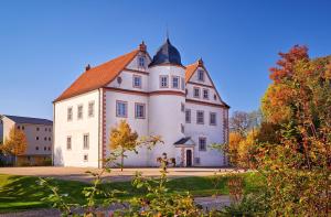 a large white building with a turret at Maaß'ens Ferienhaus in Wildau