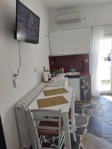 een keuken met een tafel en een tv aan de muur bij Apartment LUNA in Búrbuli