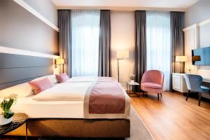 um quarto de hotel com uma cama e uma secretária em Welcome Hotel Residenzschloss Bamberg em Bamberg